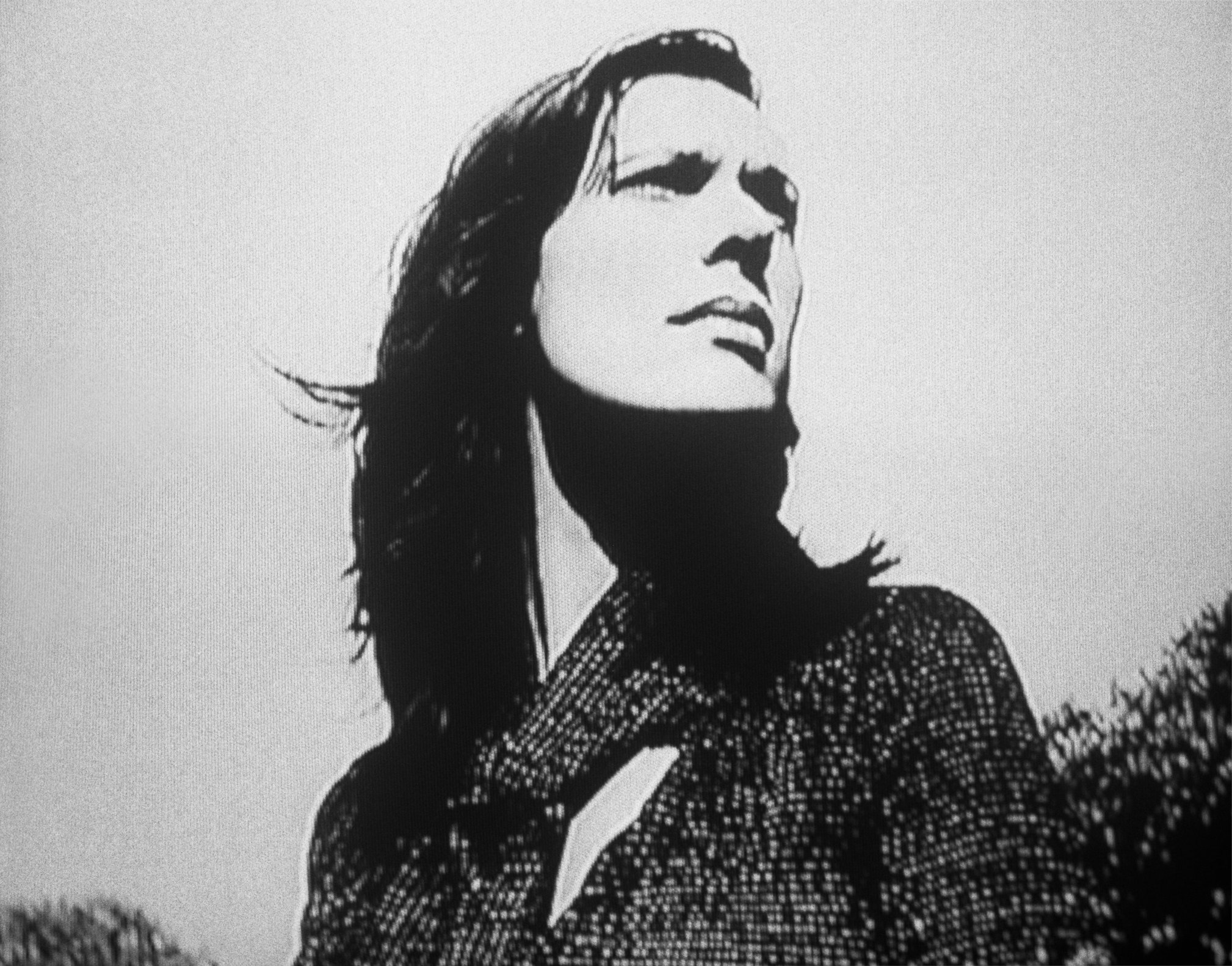 Laetitia Sadier, en blanco y negro, vista desde abajo, con el rostro alzado y el pelo largo sobre un jersey de punto.