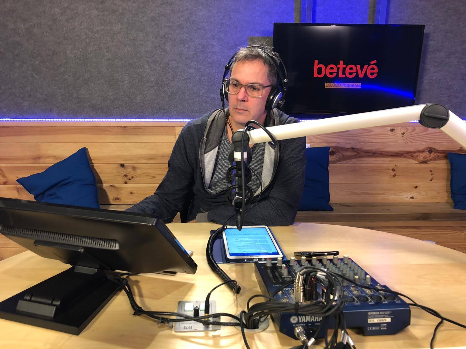 Nando Cruz en un estudio de radio, con auriculares y micrófono, durante una locución.